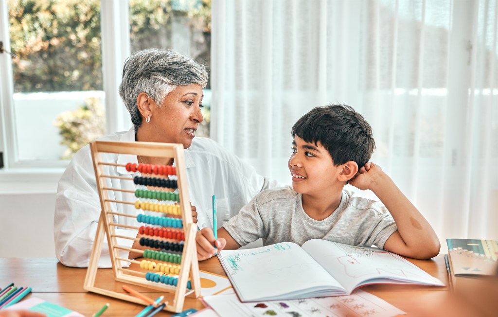 Grandparent teaching child showing importance of life insurance for kids.