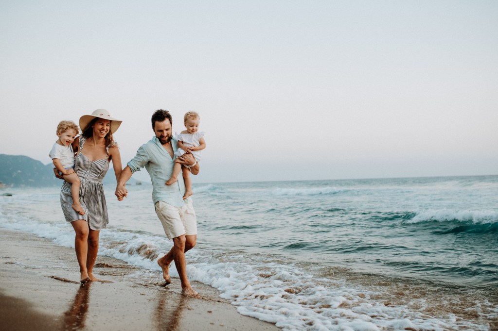 Parents with children on beach representing Generational Wealth foundations.